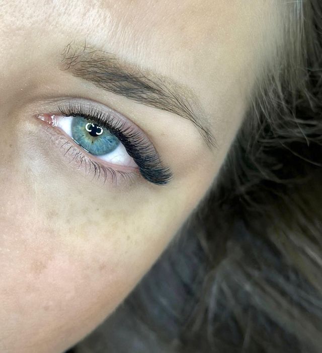 Wet-look lash extensions on blue eyes